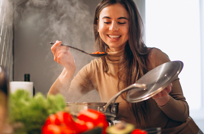 mulher provando uma comida bem temperada e aromática